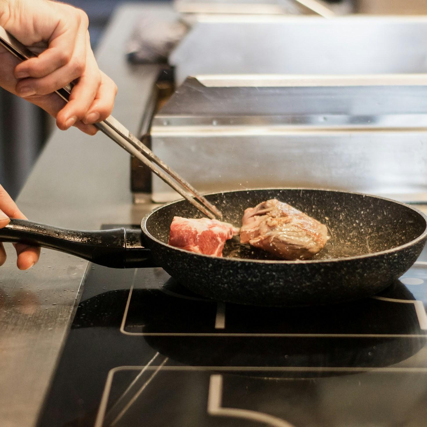 People collaborating in a modern kitchen space, exchanging recipes and cooking techniques